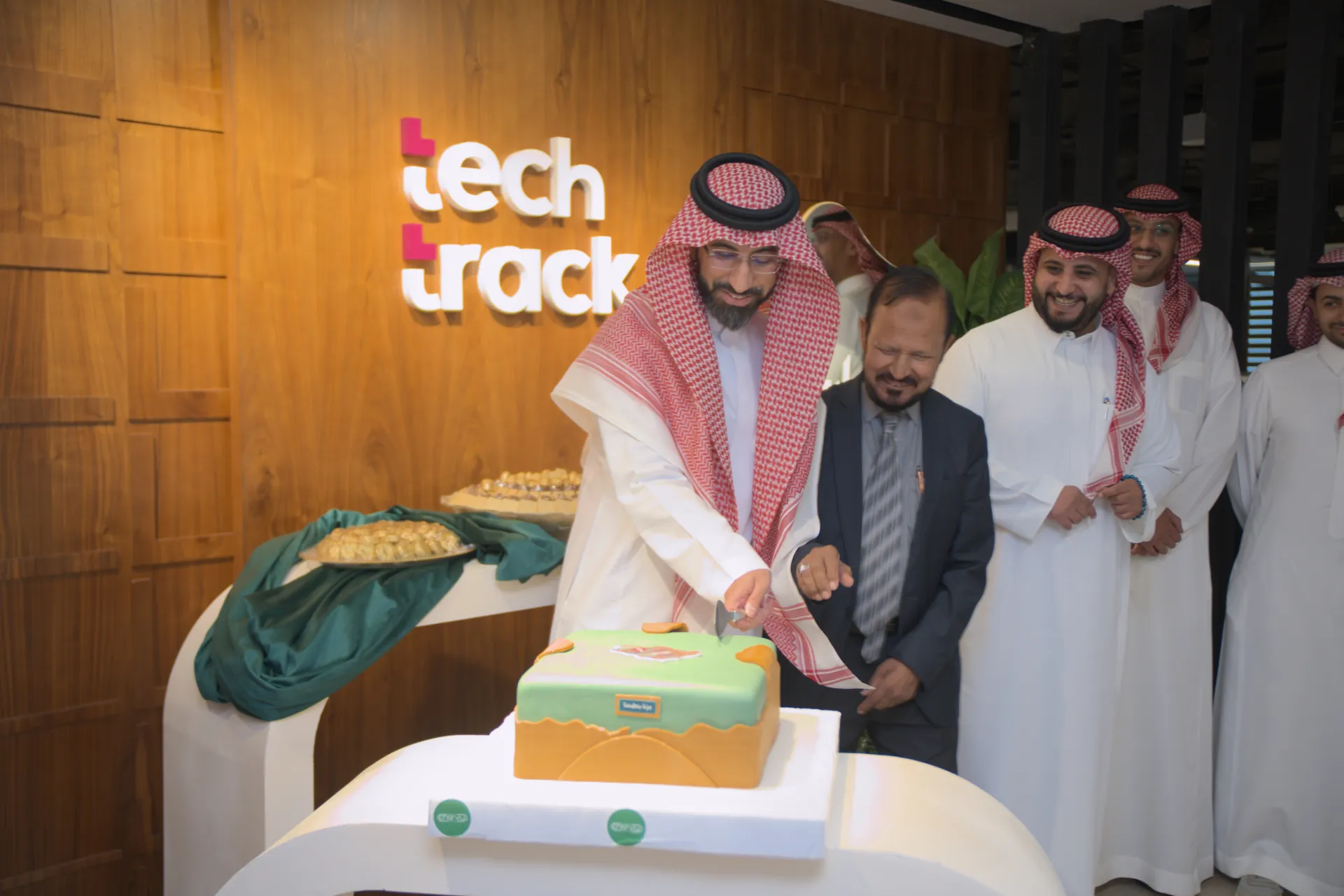 TechTrack leadership and team cutting the National Day cake at the TechTrack office